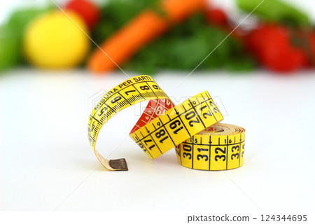 diet concept with measuring tape . fresh vegetables on a white background. Selective focus. diet concept with measuring tape . fresh vegetables on a white background. Selective focus. 124344695