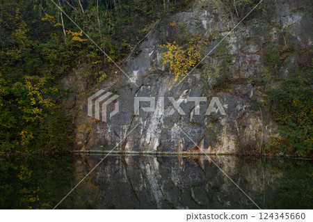Autumn forest lake in Poland. Autumn lake in autumn forest. The autumn foliage of the trees is reflected in the lake water 124345660