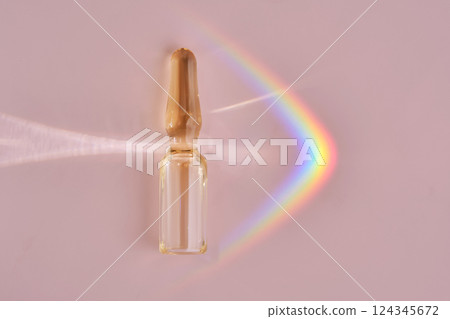 An ampoule with a medical product or cosmetic product on a pink background. An ampoule with a medical product or cosmetic product on a pink background. 124345672