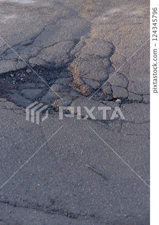 potholes in the road, holes in the asphalt on the roadway or highway.  124345796