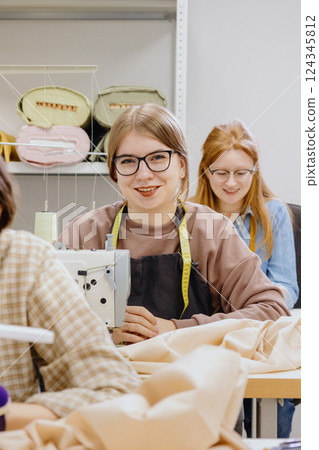 Three women sew in workshop at clothing factory. industrial equipment sewing machines. Three women sew in workshop at clothing factory. industrial equipment sewing machines. 124345812