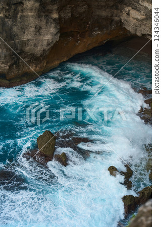 Cinematic aerial landscape shots of the beautiful island of Nusa Penida. Huge cliffs by the shoreline and hidden dream beaches with clear water and foaming wave. 124346044