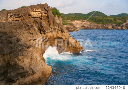 Cinematic aerial landscape shots of the beautiful island of Nusa Penida. Huge cliffs by the shoreline and hidden dream beaches with clear water and foaming wave. Cinematic aerial landscape shots of the beautiful island of Nusa Penida. Huge cliffs by the shoreline and hidden dream beaches with clear water and foaming wave. 124346048