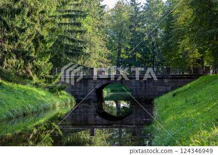 Old bridge in the park. Sunny weather. Warm summer day. Old bridge in the park. Sunny weather. Warm summer day. 124346949