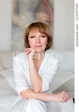 Beauty woman sitting at stylish bright living room and looking at camera. 124347504