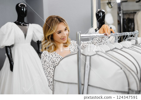 Young beautiful woman chooses a dress for wedding in a wedding salon 124347591