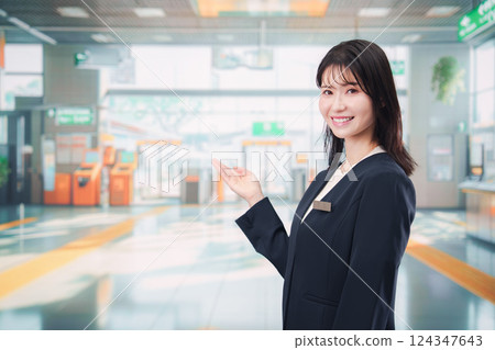 A young female staff member giving directions at the station A young female staff member giving directions at the station 124347643