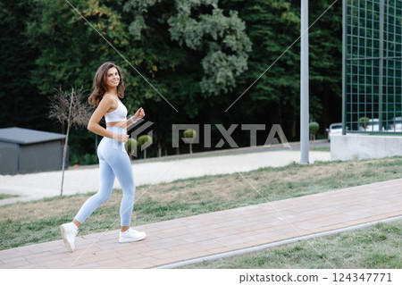 Young sportswoman running in the park enjoying her workout 124347771