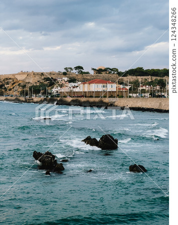 Venetian fortress of Rethymno, Crete, Greece, stands on hill overlooking mediterranean sea, with waves crashing against rocks and coastline. Panoramic view showing sea with rocks and waves crashing 124348266