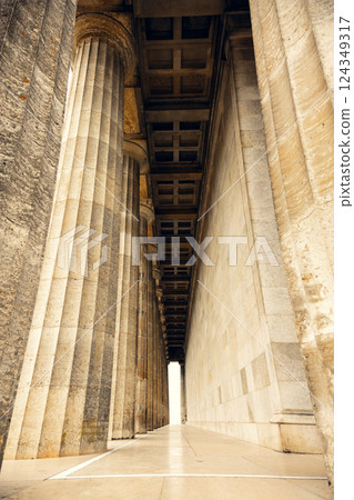 Majestic neoclassical colonnade with grand stone columns and an intricate ceiling. Symmetrical 124349317