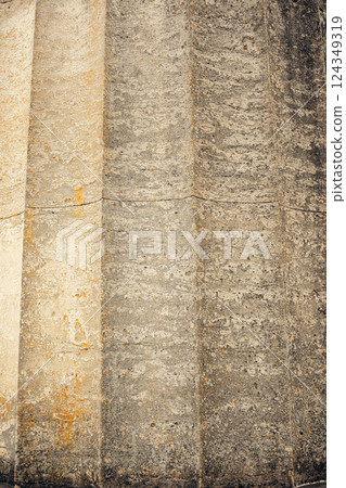 Old stone column showcasing vertical grooves and a rough, weathered texture. The aged surface and 124349319