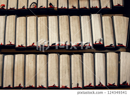 Stacked vintage books with worn edges and bookmarks, top view. Warm tones, academic and literary Stacked vintage books with worn edges and bookmarks, top view. Warm tones, academic and literary 124349341