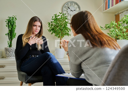 Sad unhappy young woman at therapy with female professional psychologist 124349500