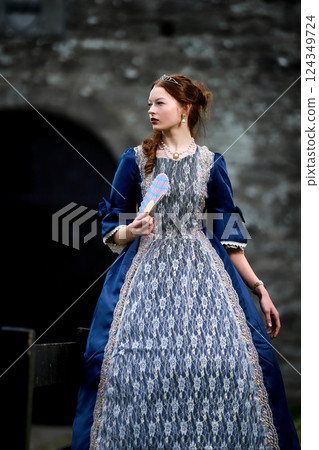 Portrait of a young redhead girl in Victorian style dress posing beside castle Portrait of a young redhead girl in Victorian style dress posing beside castle 124349724