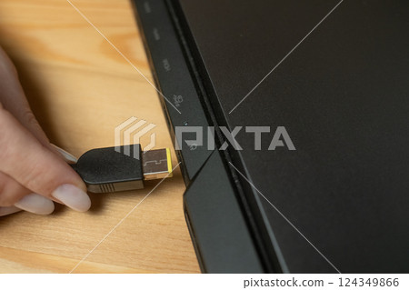 Connecting a charger to a laptop in a home office setting for efficient device charging Connecting a charger to a laptop in a home office setting for efficient device charging 124349866