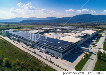Modern factory utilizing solar panels on roof for sustainable energy production 124350036