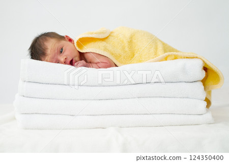 Newborn baby girl sleeps on a towel Newborn baby girl sleeps on a towel 124350400
