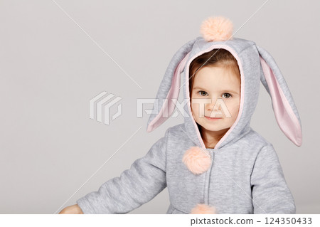Adorable Toddler in Bunny Costume Smiling on White Grey Background 124350433