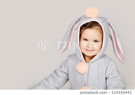 Adorable Toddler in Bunny Costume Smiling on White Grey Background 124350441
