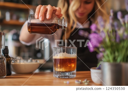 Bartender pouring syrup into iced coffee cocktail in a cafe 124350530