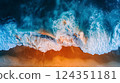 The mesmerizing aerial photo beautifully captures a stunning sunset reflecting on ocean waves, blending blue and orange tones in a display of natures majesty and tranquility 124351181