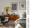A stylish bedroom featuring midcentury furniture, modern art prints, and a cozy atmosphere. Ideal for interior decor enthusiasts who enjoy blending styles and creating a comfortable space 124351204