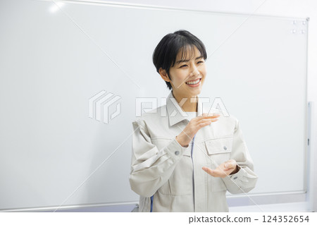 A woman in work clothes giving a presentation in a conference room A woman in work clothes giving a presentation in a conference room 124352654