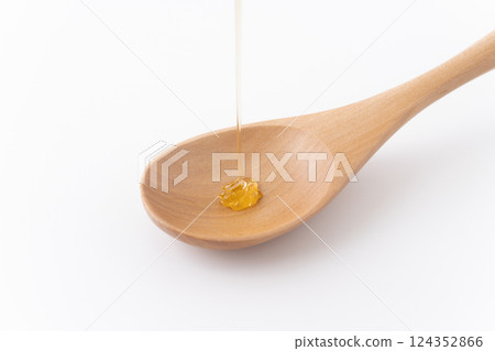 Close-up of honey dripping onto a spoon Close-up of honey dripping onto a spoon 124352866
