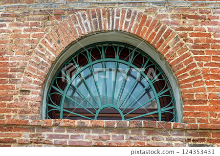 Oval window on brick wall facade 124353431