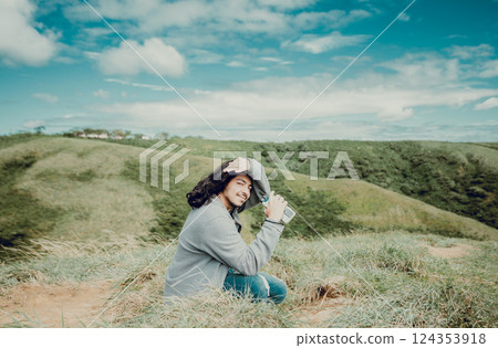 Portrait of smiling young man sitting on mountain peak. Smiling young man sitting on a hill on a sunny day Portrait of smiling young man sitting on mountain peak. Smiling young man sitting on a hill on a sunny day 124353918