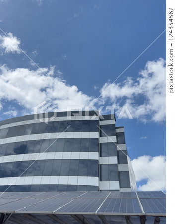 Modern architecture features solar panels against vibrant blue sky in city Modern architecture features solar panels against vibrant blue sky in city 124354562