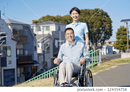 坐在輪椅上的中年婦女和護理人員，戶外，肖像，看著相機 124354756