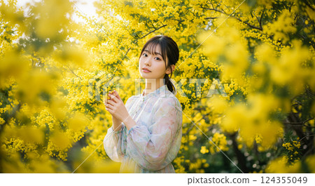 A woman smiling under a mimosa 124355049