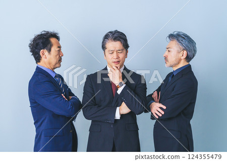 A middle-aged male business person struggling between two people 124355479