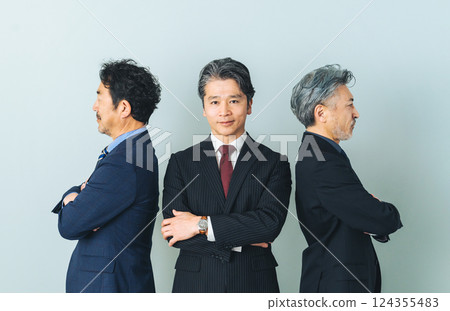 A middle-aged male business person sandwiched between two people 124355483