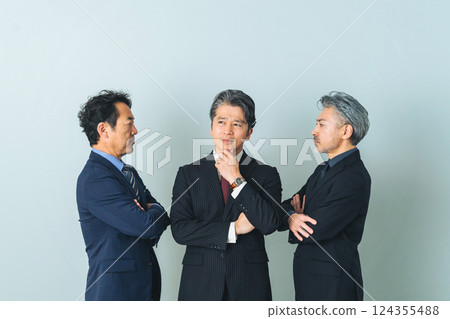 A middle-aged male business person struggling between two people 124355488