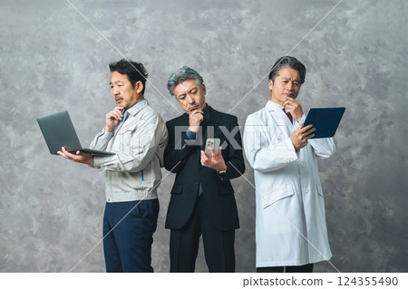 A middle-aged man from a variety of industries (engineer, business person, researcher) is troubled while looking at various digital devices. 124355490
