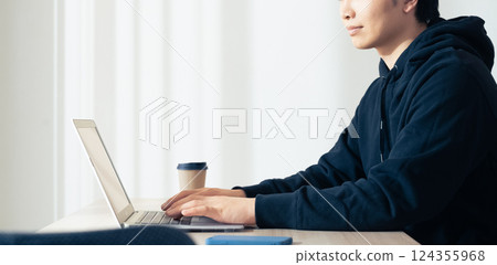 A young man using a computer 124355968