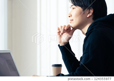 A young man using a computer 124355977