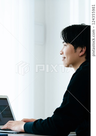 A young man using a computer 124355981
