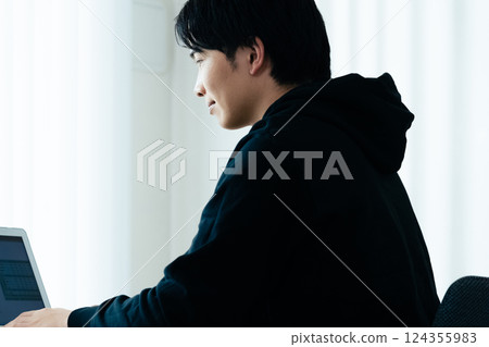A young man using a computer 124355983