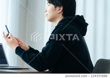 A young man using a computer 124355986