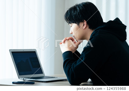 使用計算機的一個年輕人 124355988