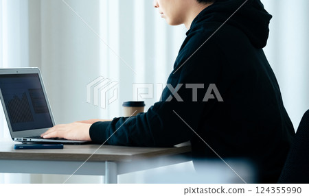 A young man using a computer 124355990
