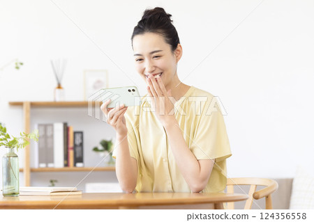 女人在客廳裡看智能手機 124356558