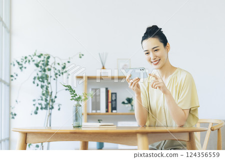woman looking at smartphone in living room 124356559