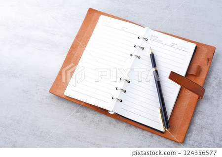 Image of a ring-type system organizer open while doing desk work 124356577