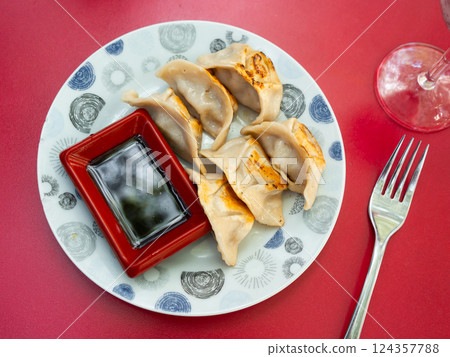 Japanese dish - dumplings gyoza with soy sauce on round plate 124357788