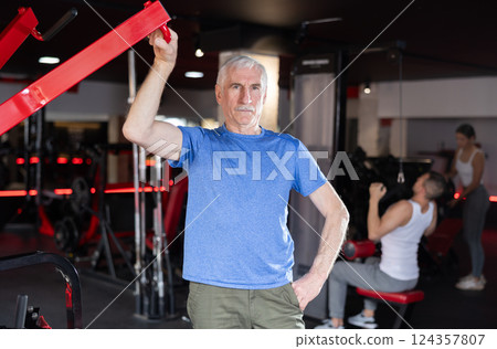 Elderly athletic man posing in gym Elderly athletic man posing in gym 124357807
