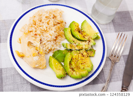 Healthy dinner of basmati rice with chicken breast and avocado 124358129